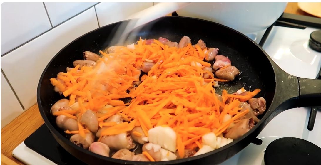 Куриные сердечки с луком и тёртой морковью на сковороде