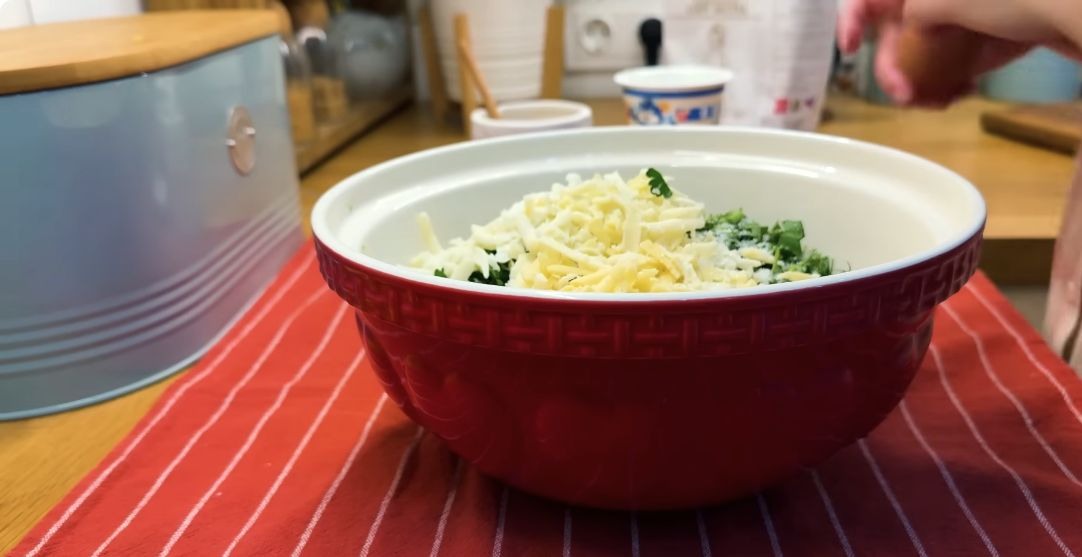 Куриное филе, рубленая петрушка и тёртый сыр в миске